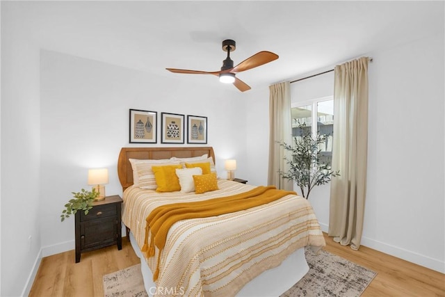 bedroom featuring a ceiling fan, baseboards, and light wood-type flooring