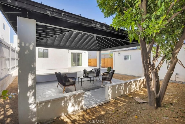 view of patio featuring an outdoor hangout area, fence, an outbuilding, and a gazebo