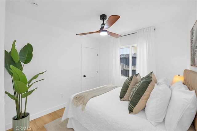 bedroom with baseboards, ceiling fan, and wood finished floors