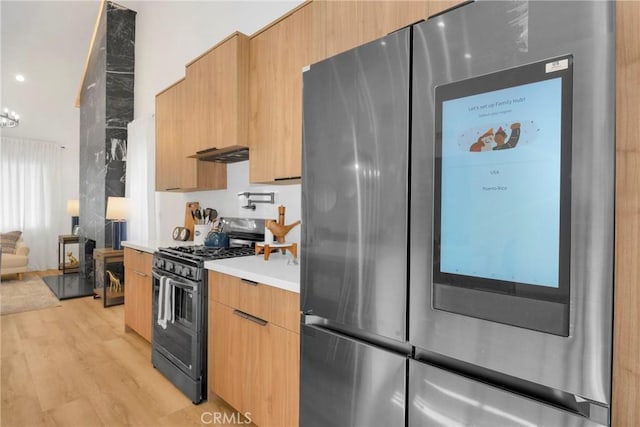 335 N Harvard Blvd, Los Angeles, CA 90004 - kitchen featuring stainless steel appliances, modern cabinets, light countertops, light wood finished floors, and under cabinet range hood