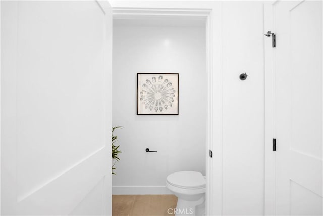 bathroom with toilet and baseboards