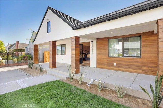 335 N Harvard Blvd, Los Angeles, CA 90004 - view of front of house with a standing seam roof, a porch, a metal roof, and stucco siding
