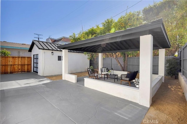 view of patio featuring a gazebo, a fenced backyard, an outbuilding, and an outdoor hangout area