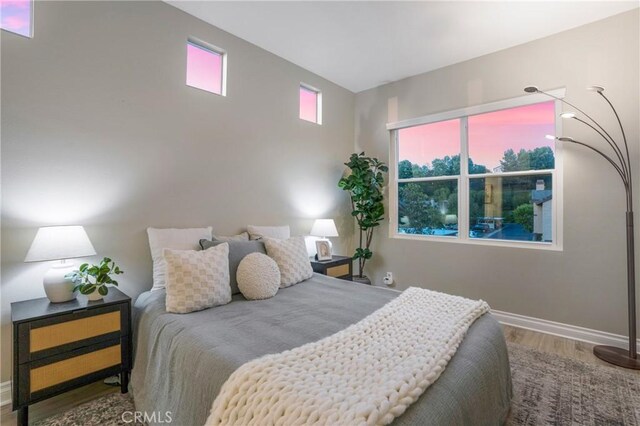 bedroom with baseboards and wood finished floors