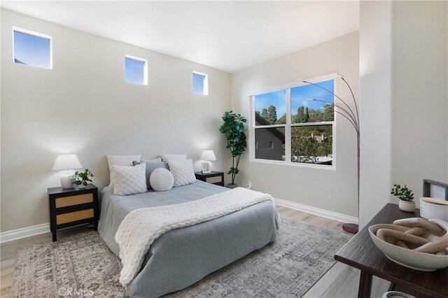 bedroom featuring light wood-type flooring and baseboards