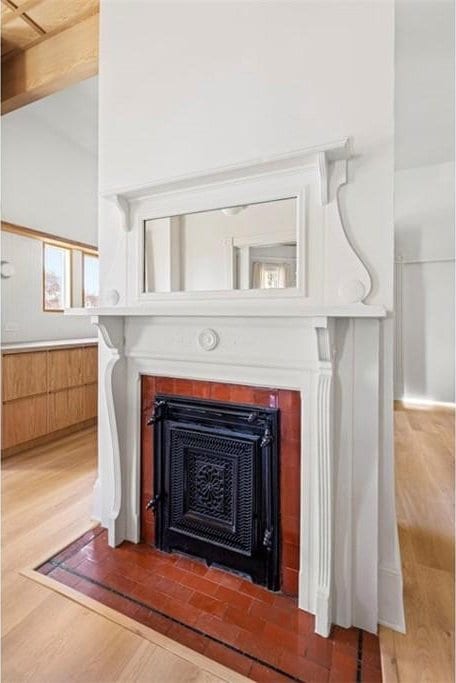 interior details with a fireplace with flush hearth and wood finished floors