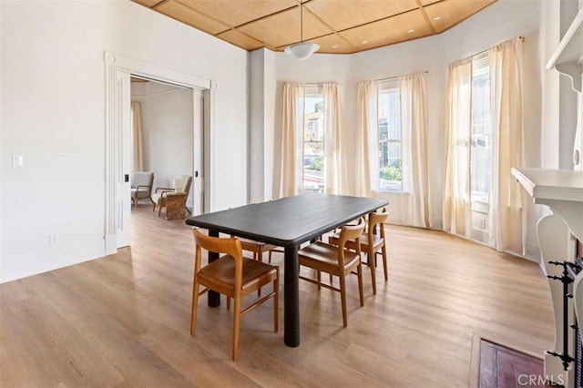 dining area with light wood-style floors and wood ceiling