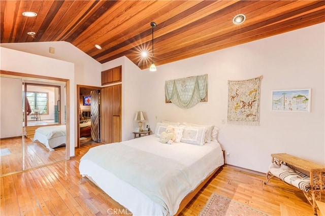 bedroom featuring a closet, vaulted ceiling, wood ceiling, and light wood-style floors