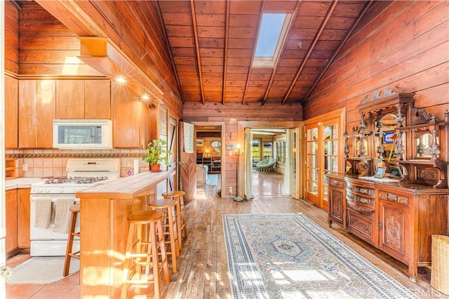 interior space featuring wood ceiling, vaulted ceiling, wood walls, and light wood-style flooring
