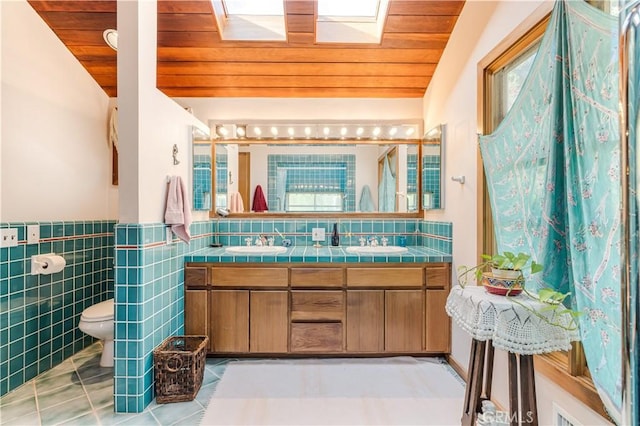 full bathroom with a sink, wooden ceiling, tile patterned floors, and toilet