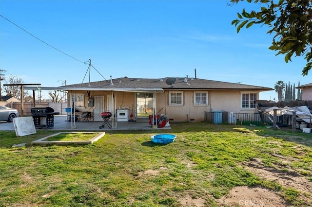 4185 E Turner Ave, Fresno, CA 93702 - back of property with a patio, a lawn, stucco siding, and fence