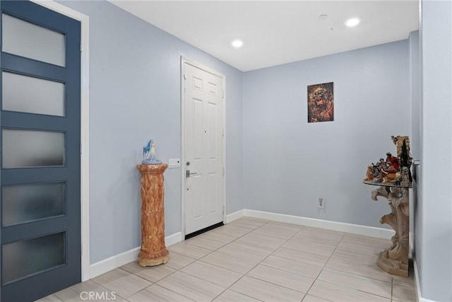 foyer featuring light tile patterned floors, baseboards, and recessed lighting