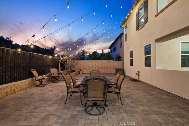 19183 Bension Dr, Saugus, CA 91350 - patio terrace at dusk featuring a fenced backyard, outdoor dining space, and a patio area