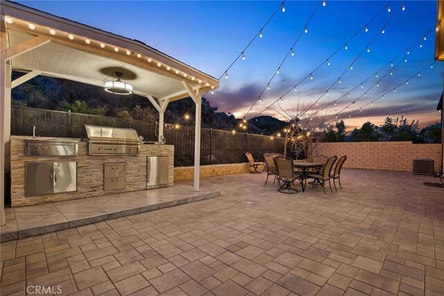 view of patio / terrace featuring area for grilling, central air condition unit, a fenced backyard, outdoor dining space, and a grill