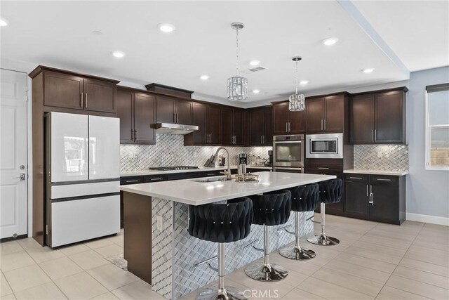 19183 Bension Dr, Saugus, CA 91350 - kitchen featuring stainless steel appliances, tasteful backsplash, light countertops, a kitchen bar, and pendant lighting