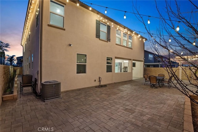 19183 Bension Dr, Saugus, CA 91350 - back of property at dusk featuring a fenced backyard, stucco siding, a patio, and outdoor dining area