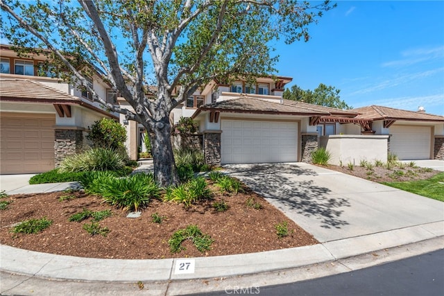 27 Birdie Ln, Coto De Caza, CA 92679 - prairie-style house featuring a garage, fence, stone siding, stucco siding, and concrete driveway