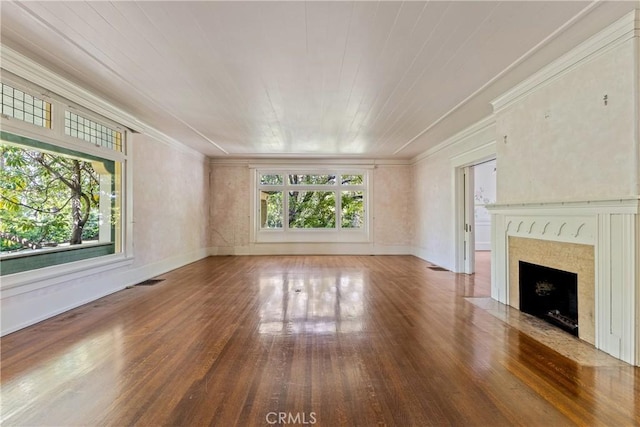 unfurnished living room featuring crown molding, baseboards, a fireplace with flush hearth, and wood finished floors
