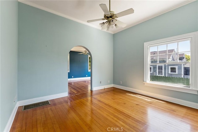 empty room featuring baseboards, ceiling fan, ornamental molding, and visible vents