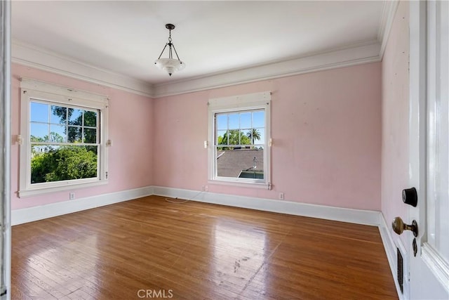 unfurnished room featuring baseboards, ornamental molding, and wood finished floors