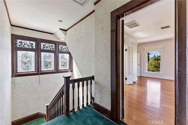 stairway featuring crown molding, baseboards, visible vents, and wood finished floors