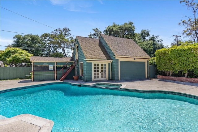 view of pool with an in ground hot tub, a patio area, fence, a fenced in pool, and an outdoor structure