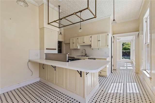 kitchen with a sink, light floors, ornamental molding, and light countertops