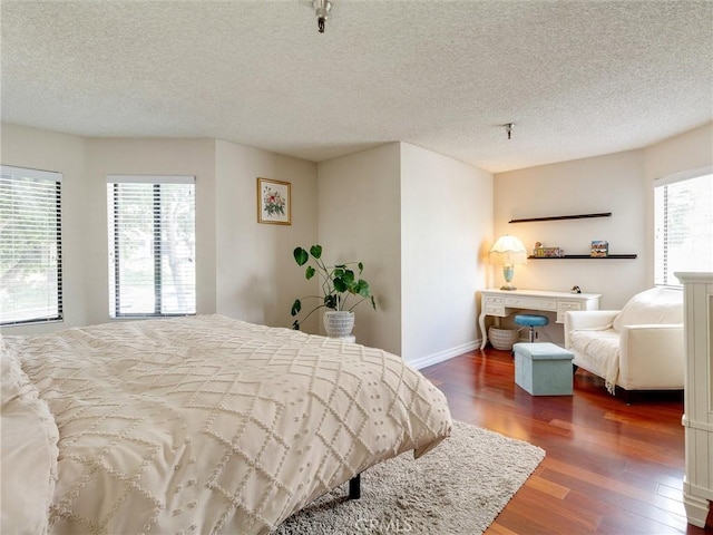 4142 E Mendez St Unit 331, Long Beach, CA 90815 - bedroom featuring dark wood-style floors, a textured ceiling, and baseboards