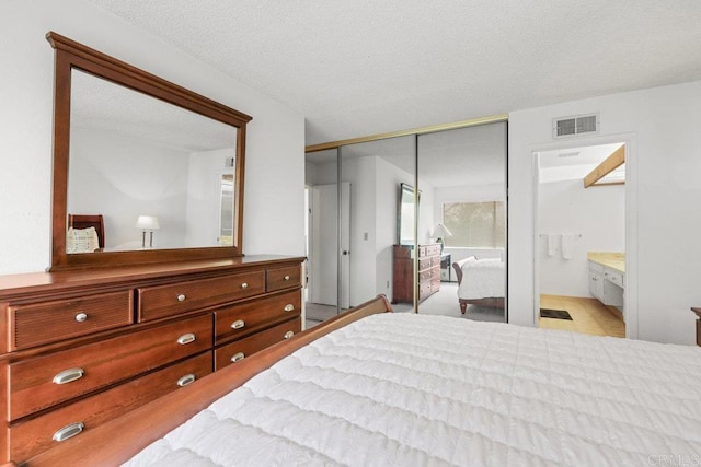 bedroom featuring visible vents, connected bathroom, and a closet