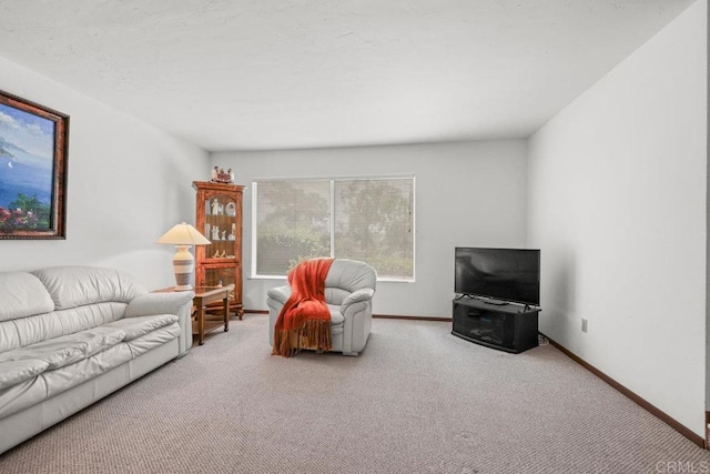 carpeted living area with baseboards