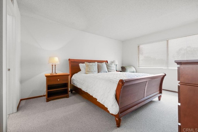 carpeted bedroom with baseboards and a textured ceiling