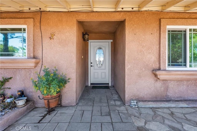 view of exterior entry featuring stucco siding