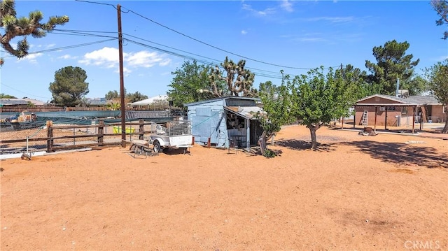 view of yard with fence and an outdoor structure