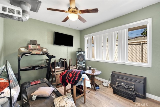 interior space featuring baseboards, ceiling fan, wood finished floors, and visible vents