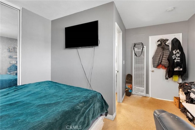 bedroom featuring carpet floors, baseboards, and a heating unit