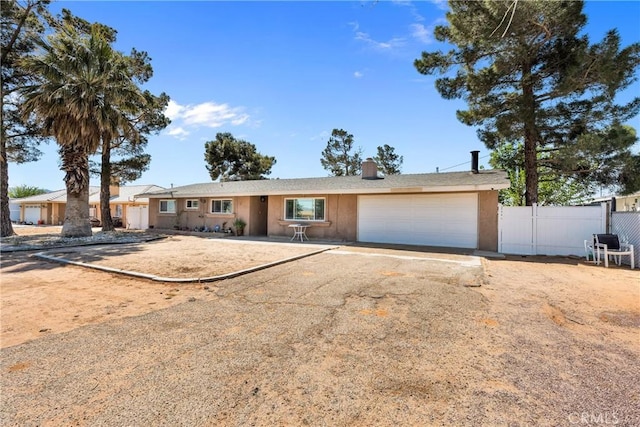ranch-style home with fence, a chimney, driveway, and a garage