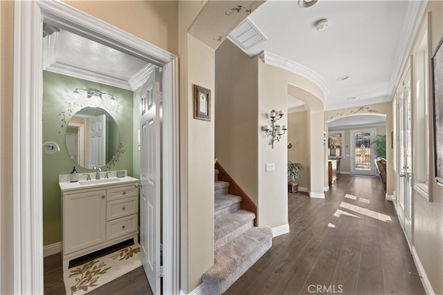 31768 Bottle Brush St, Winchester, CA 92596 - interior space featuring ornamental molding, baseboards, dark wood-type flooring, arched walkways, and a sink