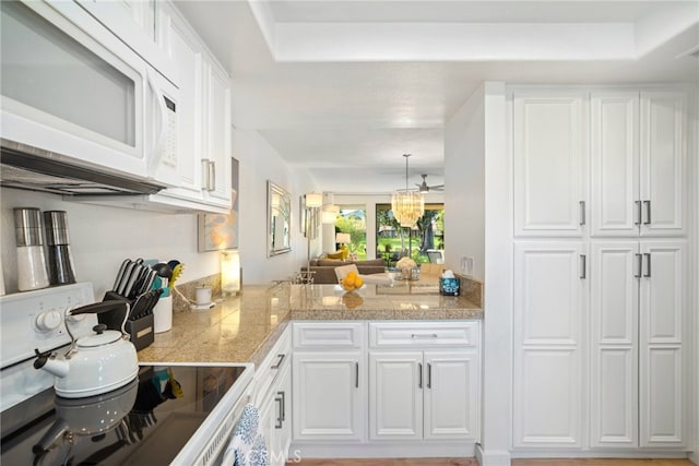 60 La Ronda Dr, Rancho Mirage, CA 92270 - kitchen with white cabinets, a notable chandelier, tile counters, stove, and white microwave