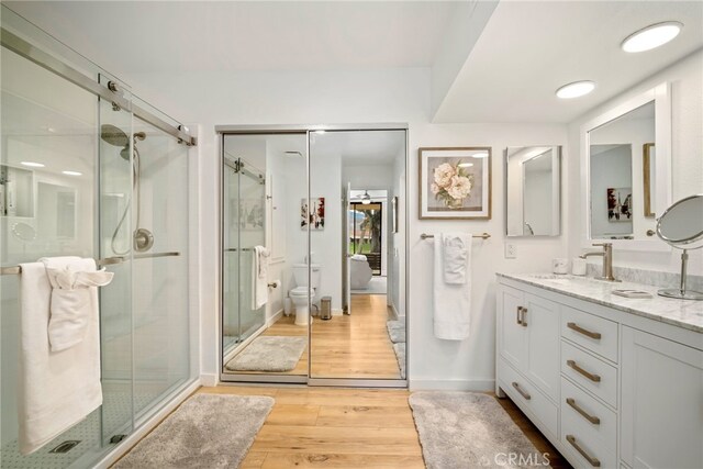 60 La Ronda Dr, Rancho Mirage, CA 92270 - bathroom with vanity, toilet, baseboards, wood finished floors, and a stall shower