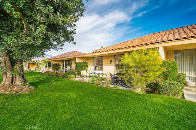 60 La Ronda Dr, Rancho Mirage, CA 92270 - rear view of property with a lawn, a patio, a tile roof, and stucco siding
