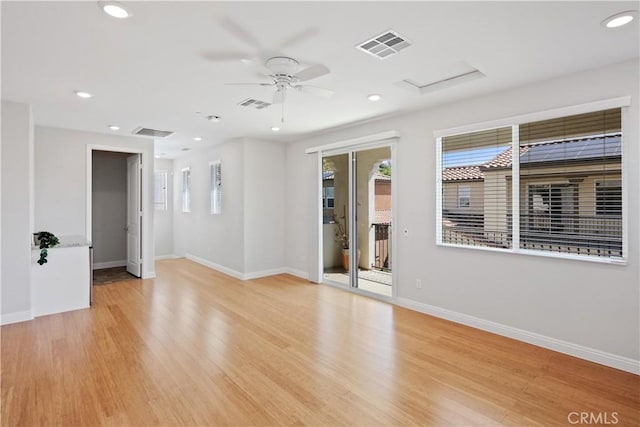 unfurnished room featuring a ceiling fan, baseboards, visible vents, and attic access