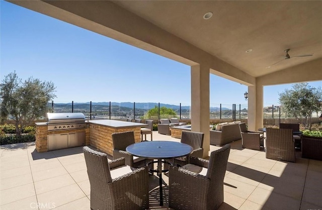 view of patio / terrace featuring an outdoor kitchen, grilling area, a mountain view, outdoor dining area, and an outdoor living space