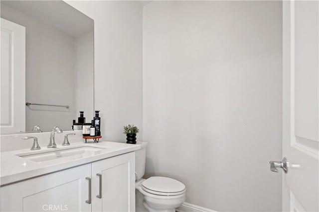 half bathroom with vanity and toilet