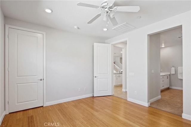 unfurnished bedroom featuring connected bathroom, baseboards, visible vents, and light wood finished floors