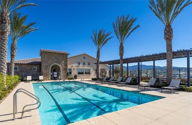 pool featuring a mountain view and a patio area
