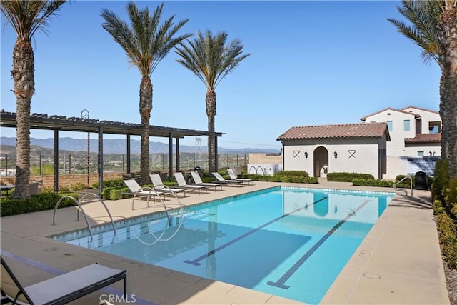 pool with a patio and a mountain view