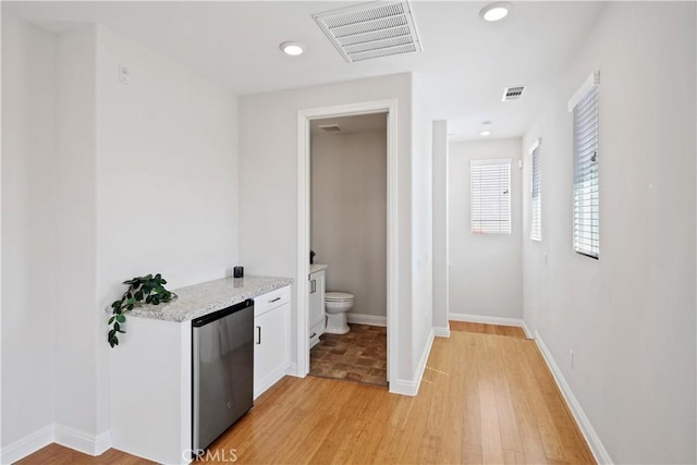 interior space with visible vents, recessed lighting, wood finished floors, and toilet