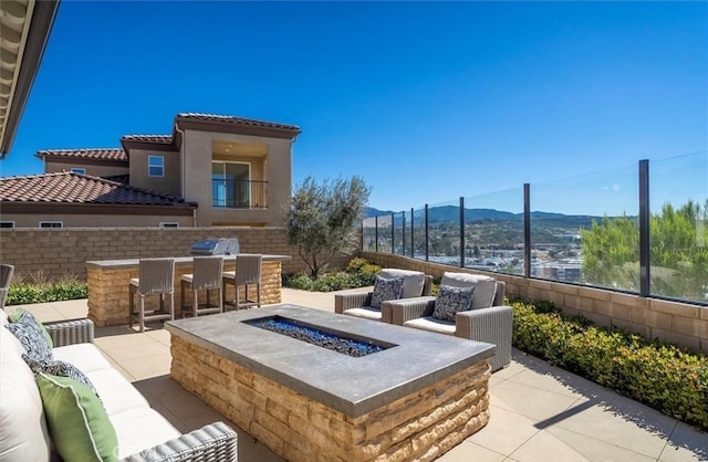view of patio / terrace with a fire pit, a mountain view, and outdoor dry bar