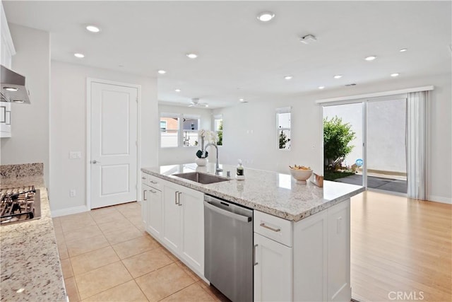 kitchen with stainless steel dishwasher, white cabinets, and a sink