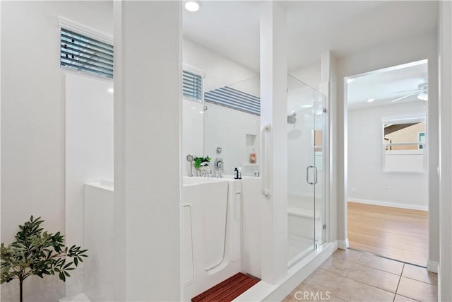 bathroom featuring tile patterned floors, baseboards, a ceiling fan, and a stall shower